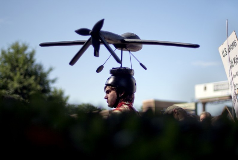 Adan Wadley, of Dunwoody, Ga., wears a drone hat as he protests against the use of drones outside the International Conference on Unmanned Aircraft Systems at the Grand Hyatt Hotel, Tuesday, May 28, 2013, in Atlanta. (AP Photo/David Goldman)