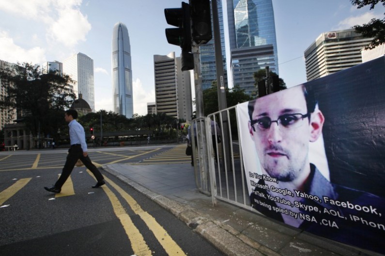 A banner supporting Edward Snowden, a former CIA employee who leaked top-secret documents about sweeping U.S. surveillance programs, is displayed at Central, Hong Kong's business district, Tuesday, June 18, 2013. President Barack Obama defended top secret National Security Agency spying programs as legal in a lengthy interview, and called them transparent — even though they are authorized in secret.  (AP Photo/Kin Cheung)