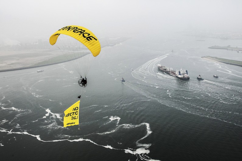 This image made available by environmental organization Greenpeace shows the Greenpeace ship Esperanza, paragliders and Greenpeace inflatable boats protest near the Mikhail Ulyanov oil tanker, right, in the harbor of Rotterdam, Netherlands, on Thursday, May 1, 2014. Greenpeace International activists are attempting to prevent a Russian tanker carrying the first oil from a new offshore platform in the Arctic from mooring at Rotterdam Port. The environmental group said Thursday it has sent two ships, Rainbow Warrior III and Esperanza, plus rubber rafts, paragliders and activists on shore, to meet the Mikhail Ulyanov, a tanker chartered by Russia's state-controlled oil company, Gazprom OAO. (AP Photo/Ruben Neugebauer, Greenpeace) NO SALES, NO ARCHIVE