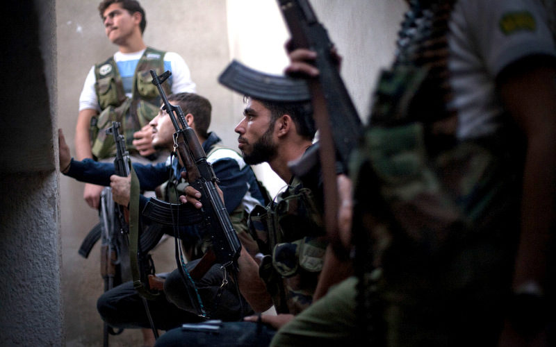 Free Syrian Army fighters take cover from incoming Syrian Army fire in the Izaa district in Aleppo, Syria, Wednesday, Sept. 12, 2012. (AP/Manu Brabo)