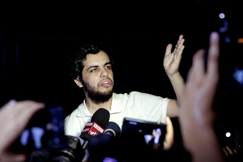 Al-Jazeera Arabic service journalist Abdullah Elshamy, center, who had been on hunger strike for more than four months to protest his prolonged detention without charges, speaks to the media after his release from detention in Cairo, Egypt, Tuesday, June 17, 2014. Elshamy was swept up with hundreds of protesters on Aug. 14, 2013 while covering the violent dispersal of a sprawling sit-in by ousted President Mohammed Morsi supporters, which saw hundreds killed and thousands wounded. (AP Photo/Nariman El-Mofty)