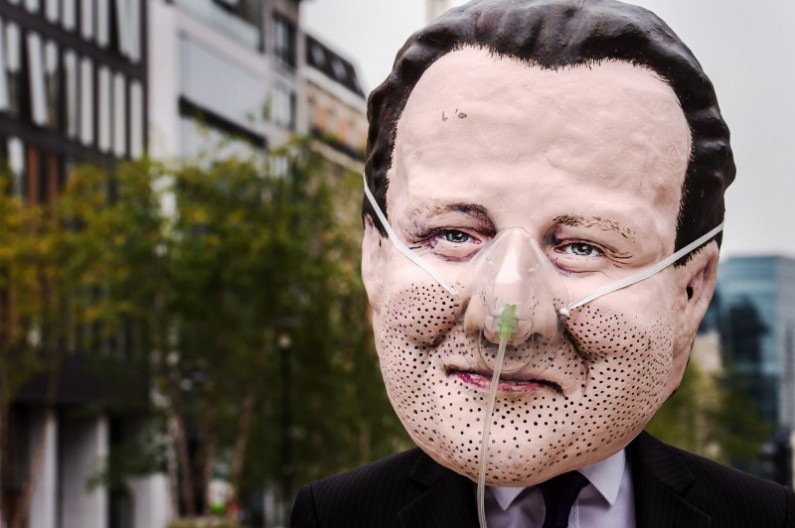 An Oxfam demonstrator wearing a mask of Britain's Prime Minister David Cameron demonstrates for an energy secure world near the EU Council in Brussels, Tuesday June 3, 2014. Oxfam says G7 leaders in Brussels can add weight to common sense, by developing an energy security plan that places energy saving, clean, affordable and renewable energy first. (AP Photo/Geert Vanden Wijngaert)