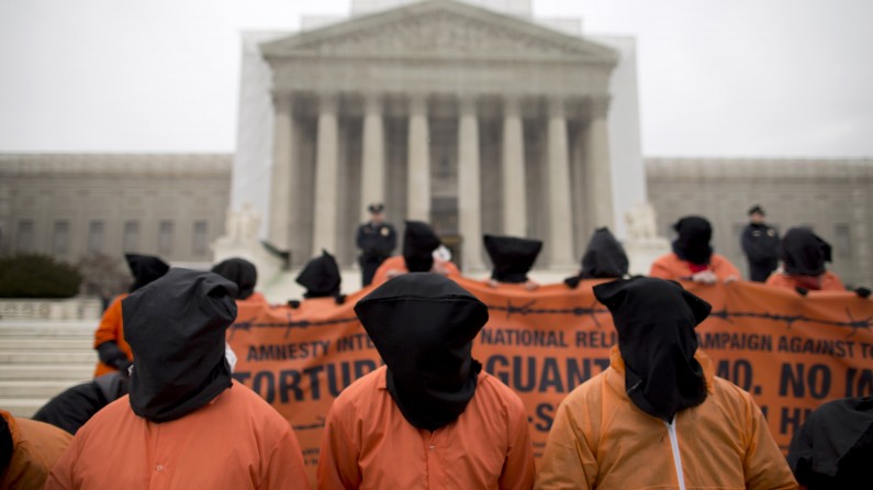 Demonstrators, dressed as detainees, protest against the U.S. military detention facility in Guantanamo Bay, Cuba, in front of the U.S. Supreme Court in Washington, Friday, Jan. 11, 2013. The protest marks the 11th anniversary of the first detainees being jailed at Guantanamo Bay. (AP Photo/ Evan Vucci)