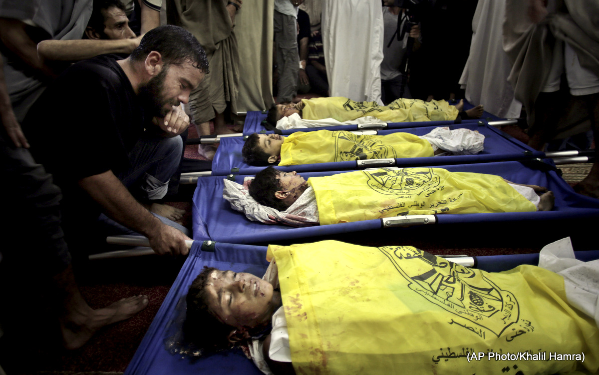 Palestinians mourn over the lifeless bodies of four boys