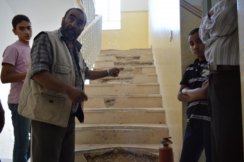 Mohammed Abu Aisha points to the smashed stairs in the extended family's home. All of the stairs, sinks, mirrors and windows in the four family building were smashed. (Photo by Sharen Khalel for MintPress News)