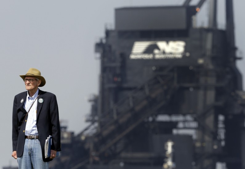 In this May 22, 2014 photo, Joe Cook, an activist with the Virginia chapter of the Sierra Club, stands outside of Norfolk Southern's Lamberts Point coal terminal in Norfolk, Va. A substance that Cook believes is coal dust has been found on houses near the facility. Believing the discovery is a health concern to local residents, he is urging for a reduction in coal exports out of Norfolk. (AP Photo/Patrick Semansky)