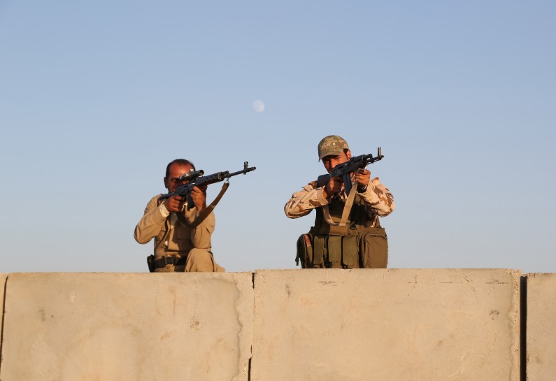 In this Aug. 8, 2014, photo, Kurdish Peshmerga fighters stand guard during airstrikes targeting Islamic State militants at the Khazer checkpoint outside of the city of Irbil in northern Iraq. For years, Kurdish officials have beseeched the Obama administration to allow them to purchase American weapons. And for just as long, the administration has rebuffed the Kurds, America’s closest allies in Iraq. (AP Photo/ Khalid Mohammed)