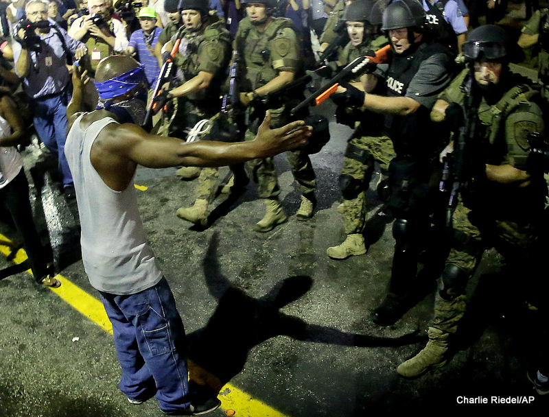 In this Aug. 20, 2014 file photo police arrest a man as they disperse a protest against the shooting of Michael Brown in Ferguson, Mo.