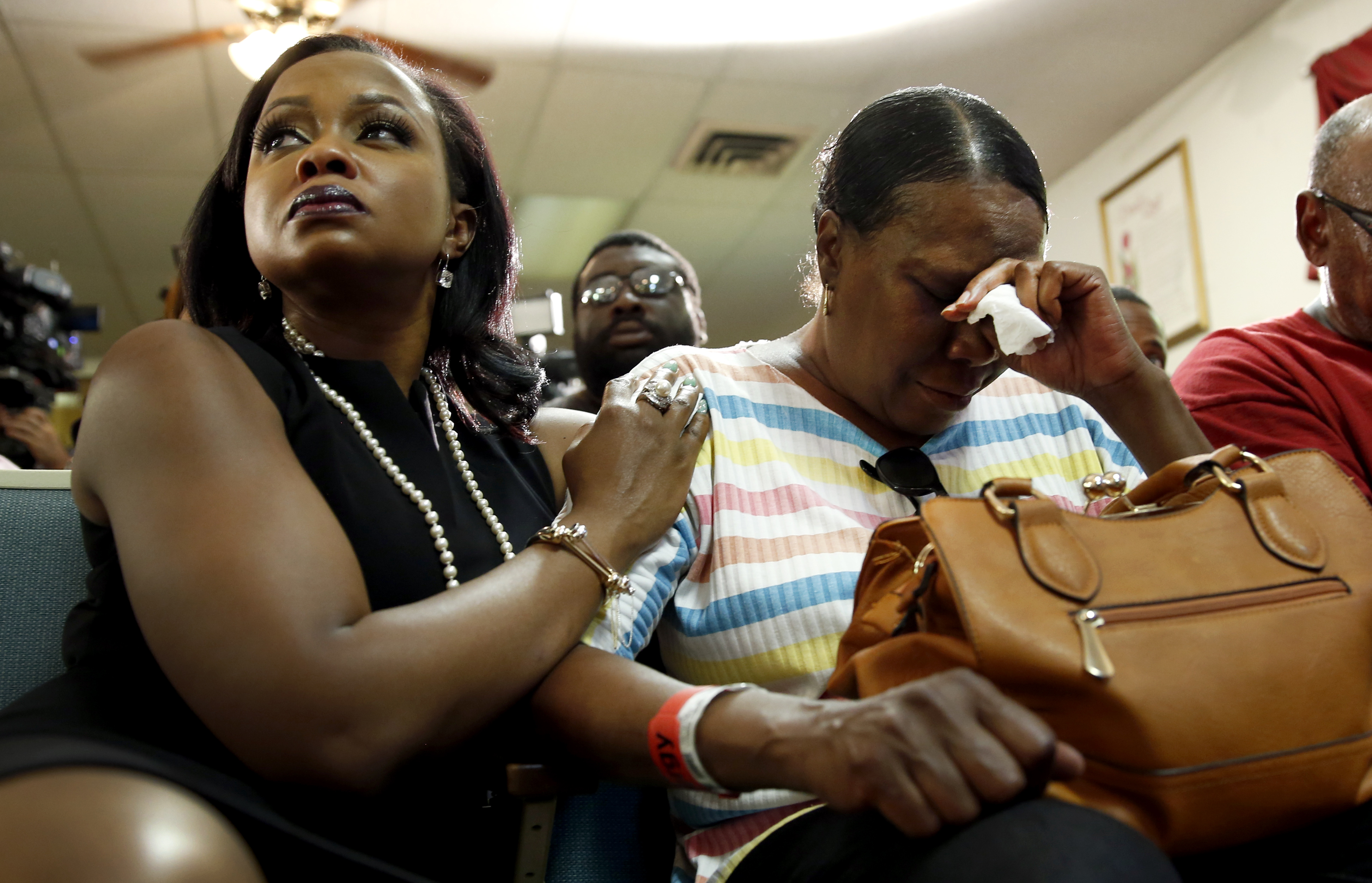 Phaedra Parks, left, comforts Desuirea Harris, the grandmother of Michael Brown, during a news conference Monday, Aug. 11, 2014, in Jennings, Mo. Michael Brown, 18, was shot and killed in a confrontation with police in the St. Louis suburb of Ferguson, Mo, on Saturday, Aug. 9, 2014.(AP Photo/Jeff Roberson)