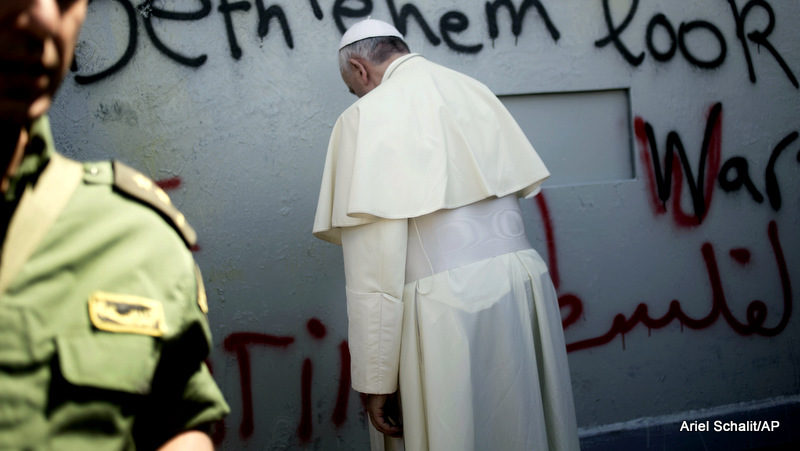 Pope Francis prays at Israel's aparthied wall on his way to a mass in Manger Square next to the Church of the Nativity, traditionally believed to be the birthplace of Jesus Christ, in the West Bank town of Bethlehem, Sunday, May 25, 2014.