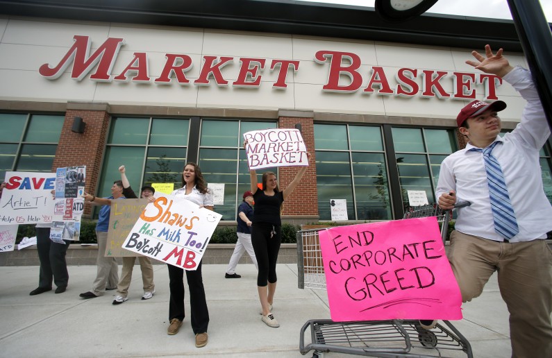 Market Basket employees Rees Gemmell, far right, and colleagues acknowledge passing supporters as they picket in front of the store in Haverhill, Mass., Thursday, July 24, 2014. Arthur T. Demoulas, the former chief executive of the Market Basket supermarket chain whose ouster has led to employee protests, customer boycotts and empty shelves, says he wants to buy the entire company. (AP Photo)