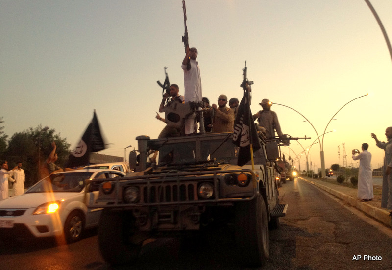 ISIS fighters parade in a commandeered American Humvee taken from Iraqi security forces down a main road at the northern city of Mosul, Iraq (AP Photo)