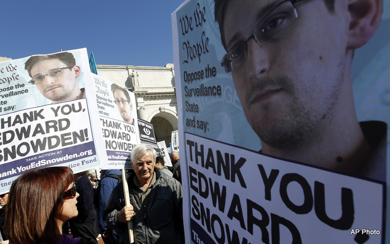 Demonstrators holds up banners with the photo of Edward Snowden during a protest outside of the U.S. Capitol in Washington, on Saturday, Oct. 26, 2013. Protesters demanded that the U.S. Congress investigate the National Security Agency's mass surveillance programs. (AP Photo/Jose Luis Magana)