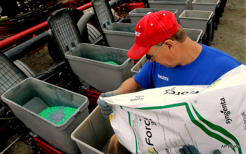 Central Illinois corn and soybean farmer Tim Seifert loads his field planter with Syngenta insecticide for refuge corn while planting DEKALB seed corn, left front, for spring planting .