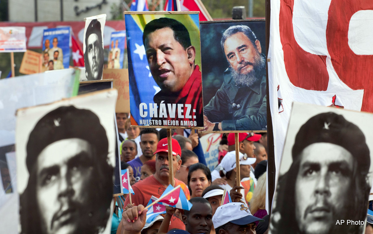 People hold up images showing Fidel Castro, second from right, Venezuela's late President Hugo Chavez, center, and Cuba's revolutionary hero Ernesto 'Che' Guevara, bottom left and right, during a May Day march in Revolution Square in Havana, Cuba, Wednesday, May 1, 2013. The image of Chavez carries the words in Spanish "Chavez : Our best friend." (AP Photo/Ramon Espinosa)