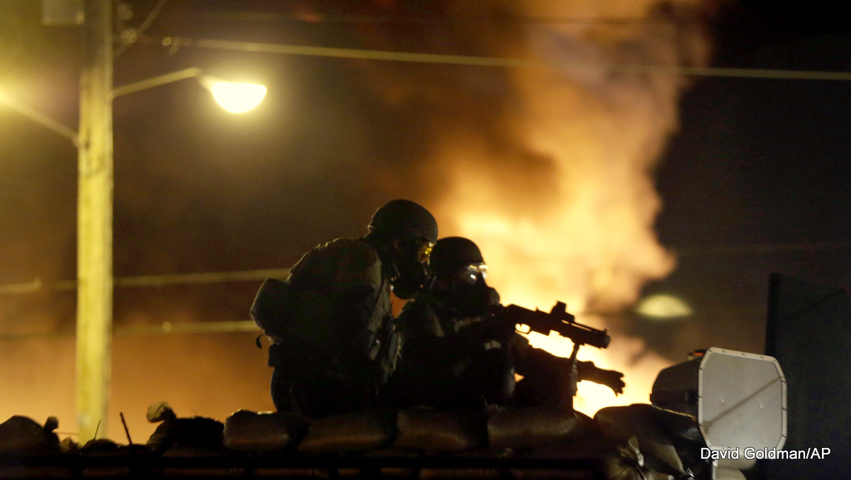 Police watch over protests which erupted after the police killing of Michael Brown, Monday, Nov. 24, 2014, in Ferguson, Mo.