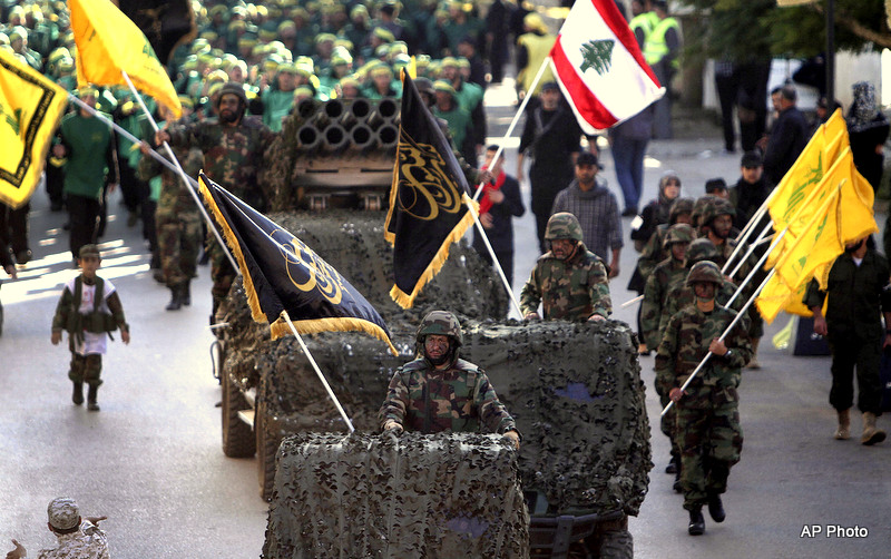 Hezbollah fighters stand on their armed vehicles