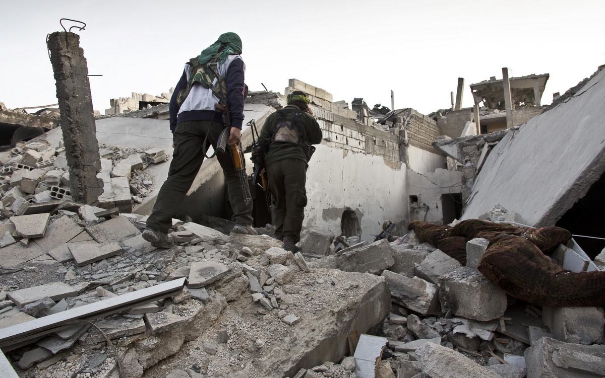 Kurdisfighters move to a secured point in the contested zone in Kobani, Syria. (Photo: Jake Simkin/AP)