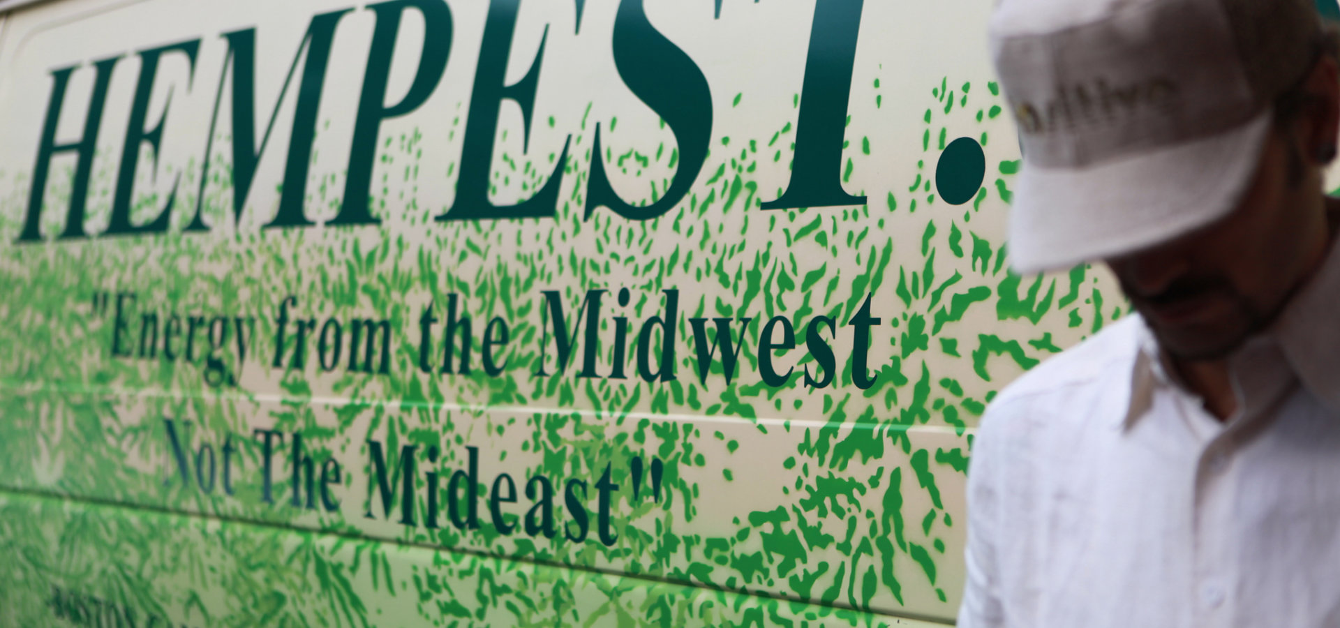 The Hempest's proprierter, wearing a baseball cap, leans against the logo van, with the slogan Energy From The Midwest Not The Mideast.