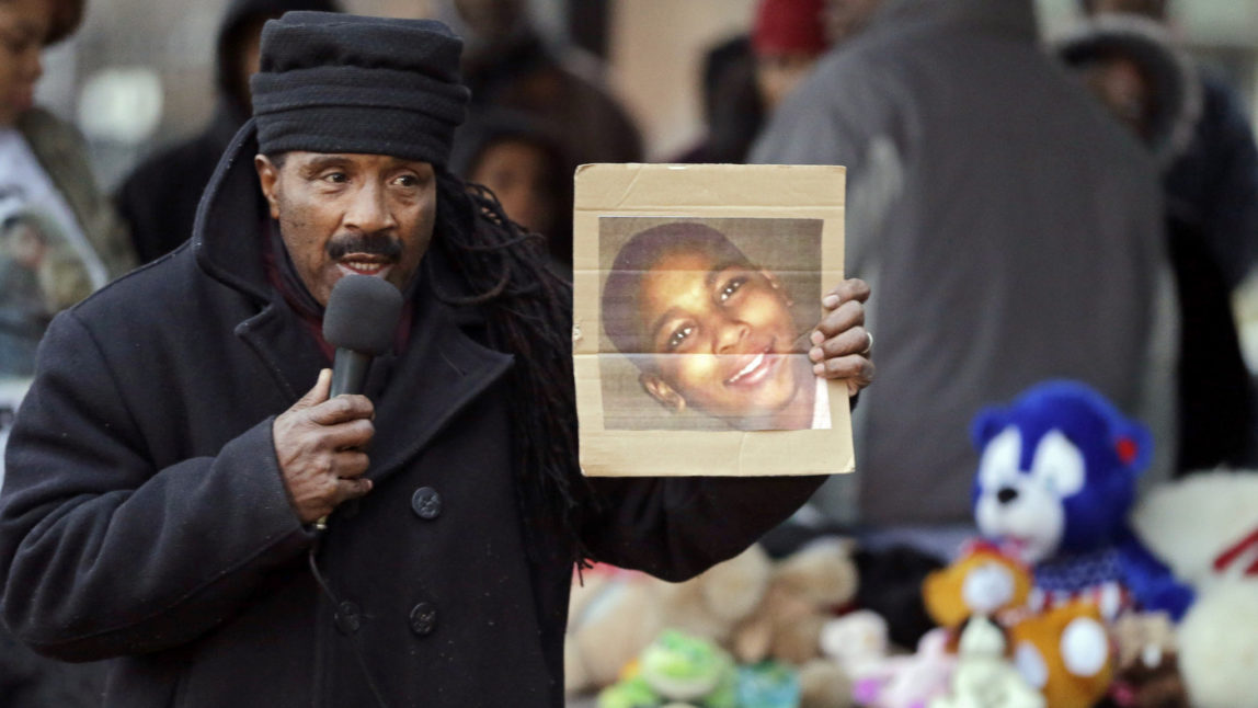 Activist Art McCoy holds a photo of Tamir Rice before a protest march at Cudell Park in Cleveland