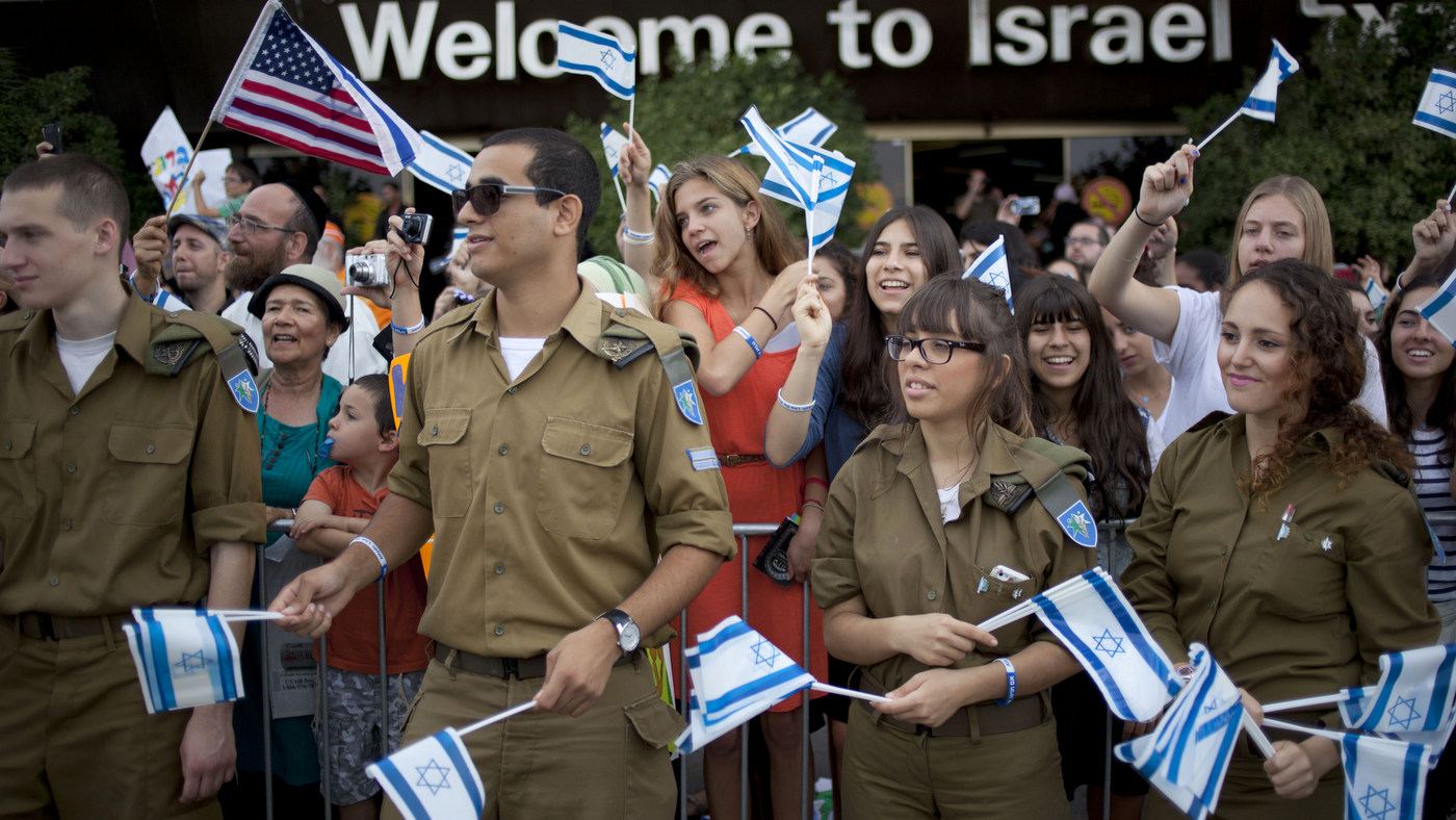 Israeli soldiers and relatives of new Jewish immigrants from the U.S. and Canada, wave Israeli flags to welcome them as they arrive at Ben Gurion airport near Tel Aviv, Israel, Tuesday, July 23, 2013. 