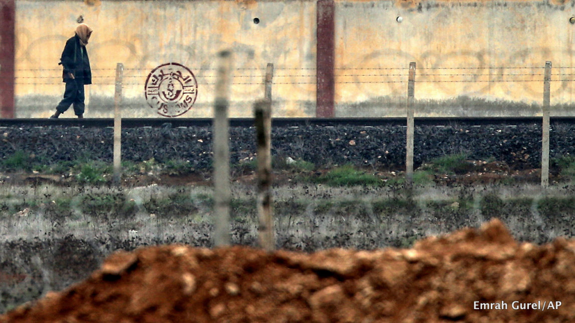 An armed man walks in ISIS controlled Tal Abyad across the Turkish Akcakale border gate, Turkey.