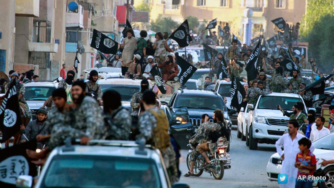 ISIS fighters parade through the streets of their de facto capital of Raqqa, Syria
