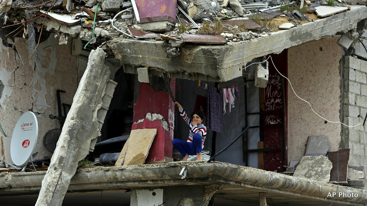 A Palestinian girl sits inside a room of her family's building which was damaged in last summer's Israel-Hamas war, in the Shijaiyah neighborhood of Gaza City, northern Gaza Strip, Monday, Feb. 23, 2015.