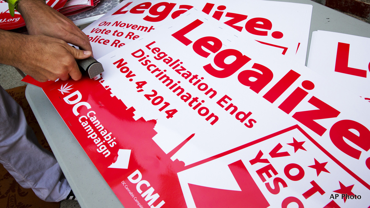 FILE - In this Oct. 9, 2014 file photo, posters encouraging people to vote yes on DC Ballot Initiative 71 to legalize small amounts of marijuana for personal use are readied in Washington. (AP Photo/Jacquelyn Martin, File)