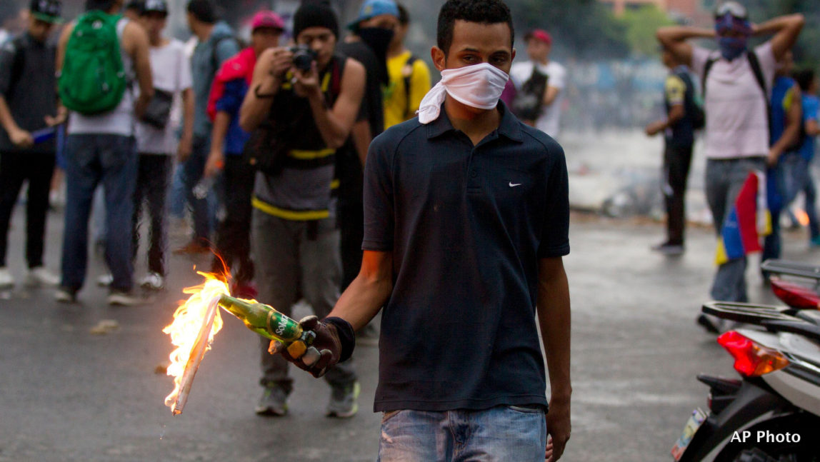 An opposition demonstrator prepares to throw a molotov cocktail at police after clashes broke out at a protest in Caracas, Venezuela, Thursday, Feb. 12, 2015.
