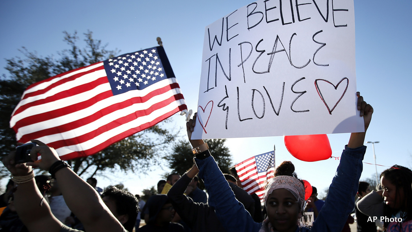 Rayan Toliver of Arlington, Texas, holds a sign that reads "We Believe In Peace & Love", as Toliver joined other supporters for a muslim conference against hate and terror at the Curtis Culwell Center, Jan. 17, 2015, in Garland, Texas. (AP Photo)