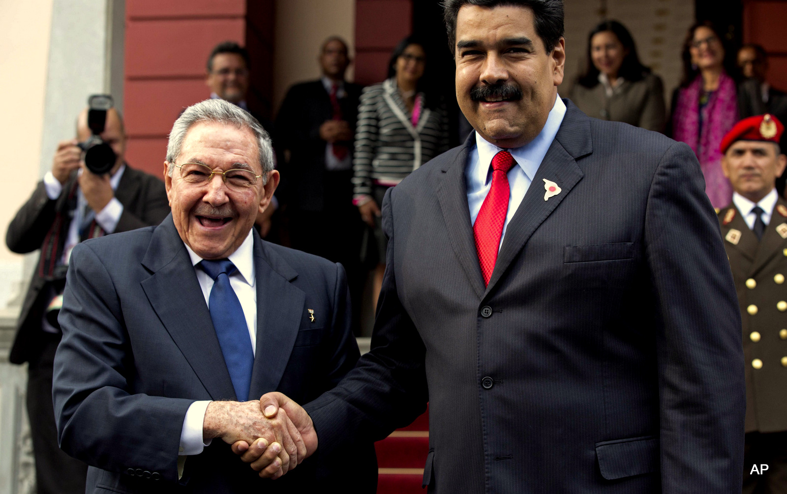 Cuba's President Raul Castro, left, shakes hands with Venezuela's President Nicolas Maduro in front of the press after arriving to Miraflores presidential palace for an emergency ALBA meeting in Caracas, Venezuela, Tuesday, March 17, 2015. 