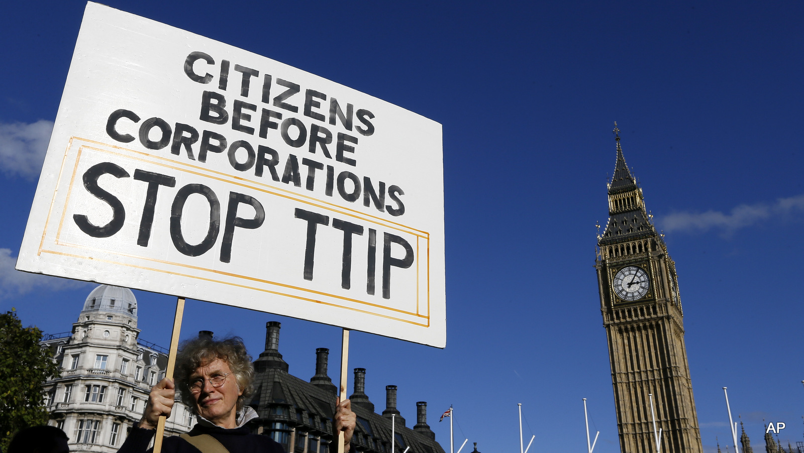 A demonstrator holds a banner in Parliament Square in London, Saturday, Oct. 11, 2014.