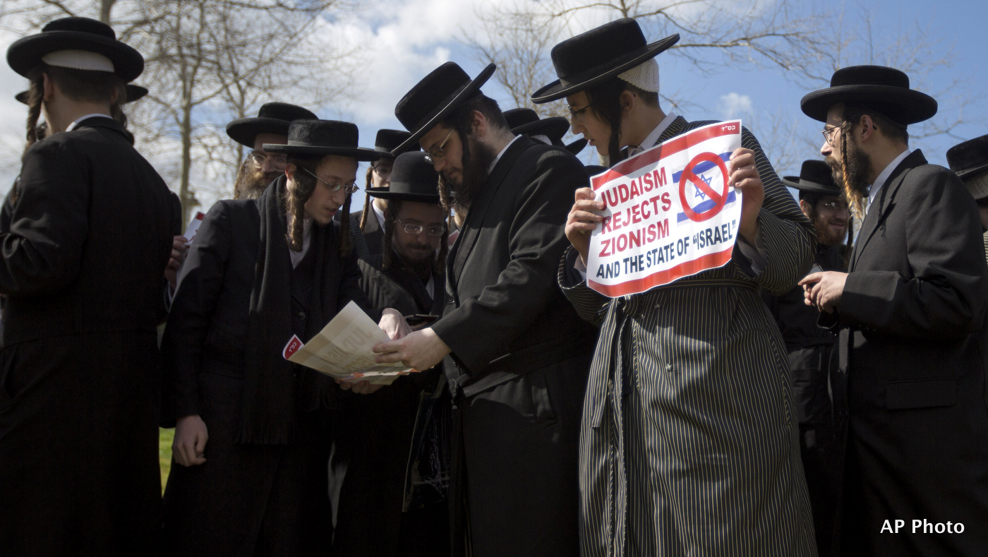 Members of the anti-Zionist ultra-Orthodox Neturei Karta group, a group that opposes Zionism and the Israeli state, hold signs during a demonstration against Prime Minister Benamin Netanyahu's U.S. visit, in front of the U.S. consulate in Jerusalem, Tuesday, March 3, 2015.  (AP Photo/Sebastian Scheiner)