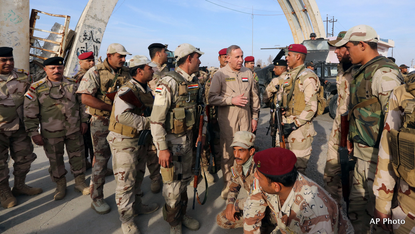 Iraqi Defense Minister Khalid al-Obeidi, center, speaks to his soldiers after a military operation to regain control of the university of Tikrit, 80 miles (130 kilometers) north of Baghdad, Iraq.