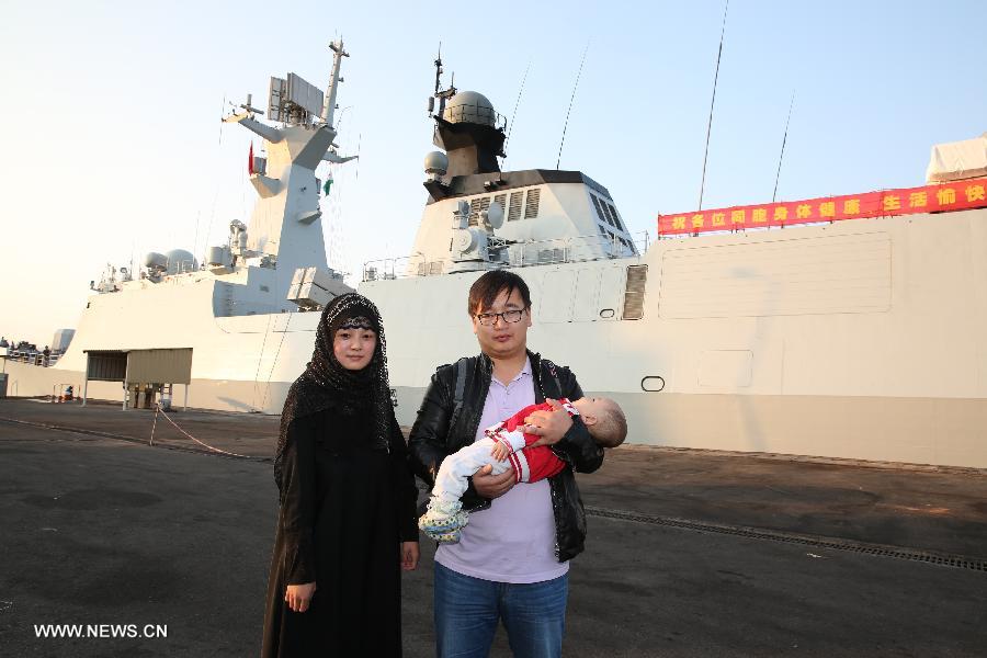 Ma Zhiqiang(R) pose with his family members in front of the missile frigate after they arrived in Djibouti, March 31, 2015. More than 500 Chinese evacuees from conflict-ridden Yemen have arrived at the Djibouti port as the situation continues to deteriorate in Yemen. (Xinhua/Pan Siwei)