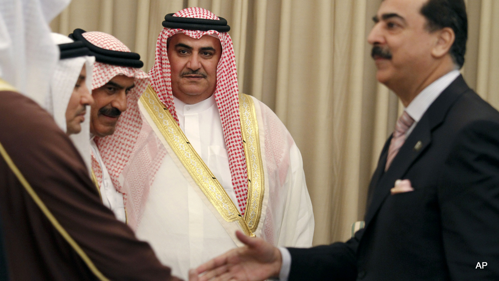 Bahrain's Foreign Minister Khalid Bin Ahmed Al Khalifa, centre left, introduces his delegate members to Pakistani Prime Minister Yousuf Raza Gilani, right, prior to their meeting in Islamabad, Pakistan on Tuesday, March 29, 2011. Khalid Bin Ahmed is in Islamabad to his two-day official visit to hold talks with Pakistani top official to discuss the current middle east situation.