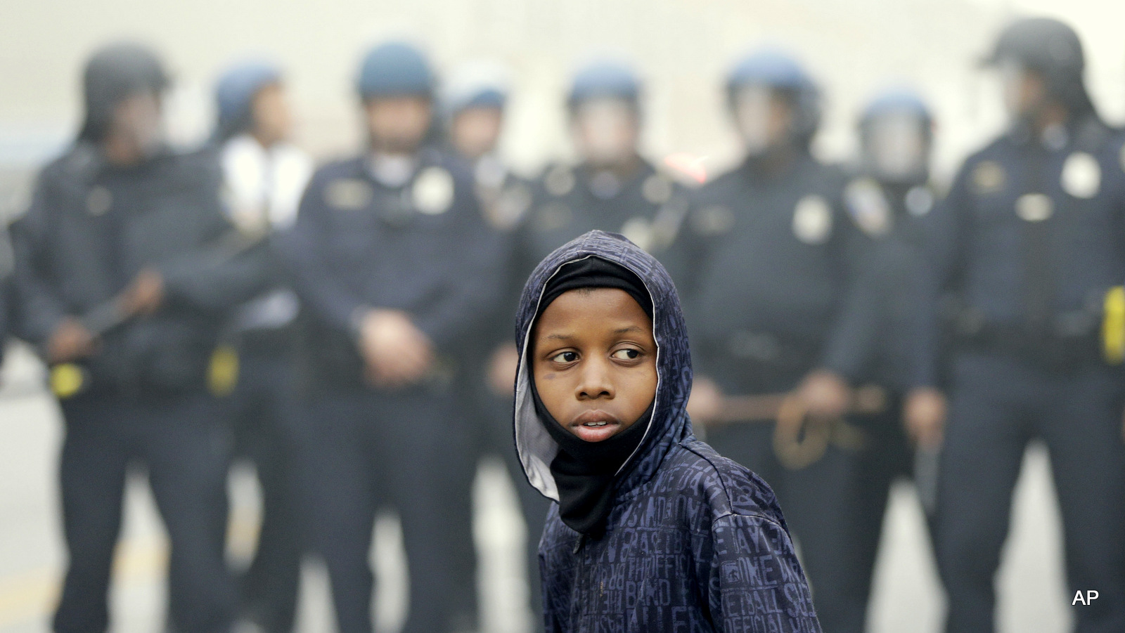A protestor stands in front of riot Police Monday, April 27, 2015, following the funeral of Freddie Gray in Baltimore. 