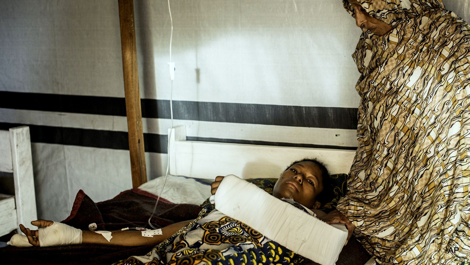 Aminatou Bello a 24-year-old Muslim, who was attacked by Christian Anti-Balaka forces, lies on a bed in Boda, Central African Republic. 