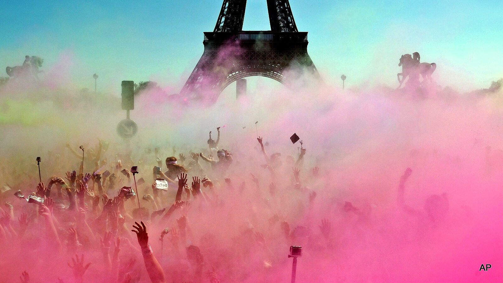 People take part in the Color Run near the Eiffel Tower, in Paris, France, Sunday, April 19, 2015. The Color Run is a 5 kilometer (3.1 mile) running event where participants are covered in bright colored powder at each check station and is less about speed and more about enjoying a day with friends and family.