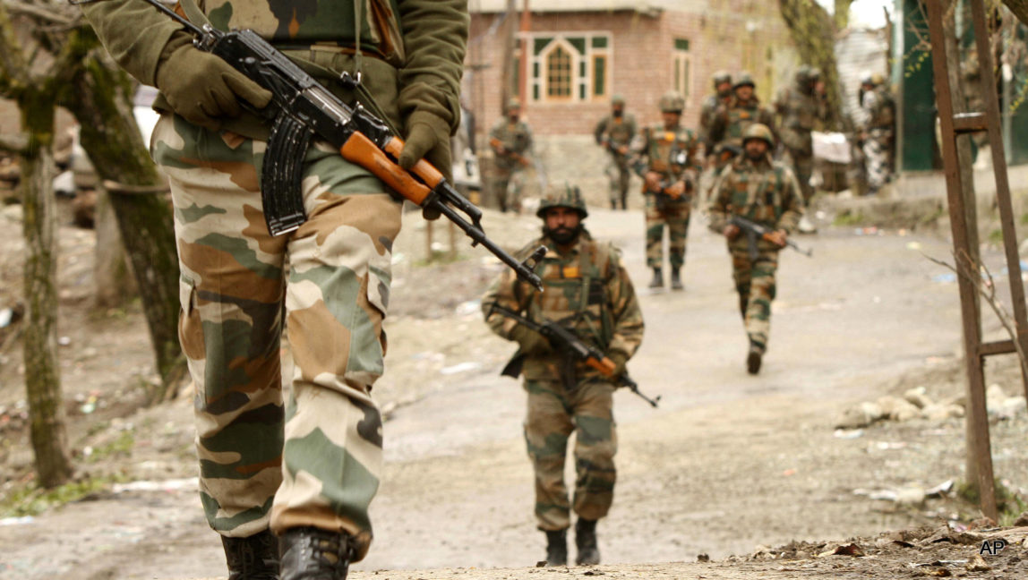Indian Army soldiers carry out a search operation for suspected rebels during a gunbattle at Hardshoora village, 35 kilometers (20 miles) north of Srinagar, India, Thursday, April 2, 2015. Suspected Kashmiri rebels and Indian security personnel were engaged in a fierce gunbattle Thursday in the Himalayan territory, officials said.