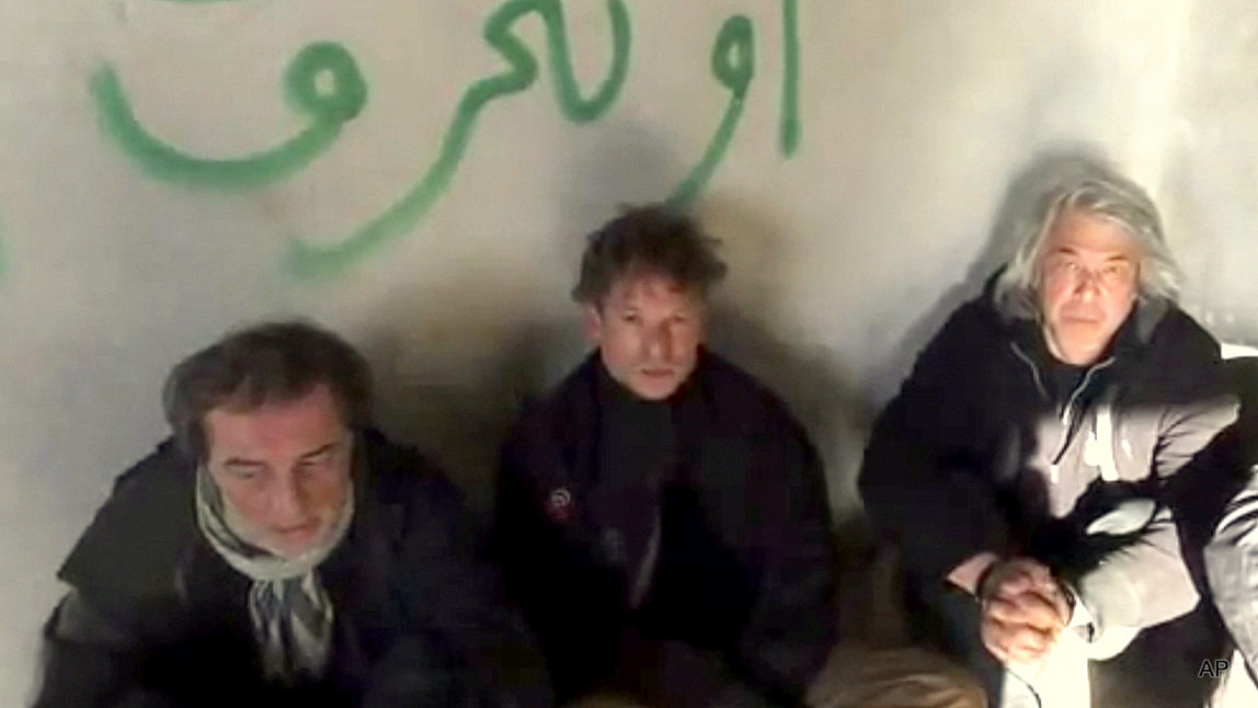 This image taken from undated amateur video posted on the Internet shows NBC chief foreign correspondent Richard Engel, center, with NBC Turkey reporter Aziz Akyavas, left, and NBC photographer John Kooistra, right, after they were taken hostage in Syria. More than a dozen heavily armed gunmen kidnapped and held Engel and several colleagues for five days inside Syria, keeping them blindfolded and tied up before they finally escaped unharmed during a firefight between their captors and anti-regime rebels, Engel claimed, but later admitted it was actually the rebels who carried out the kidnapping.