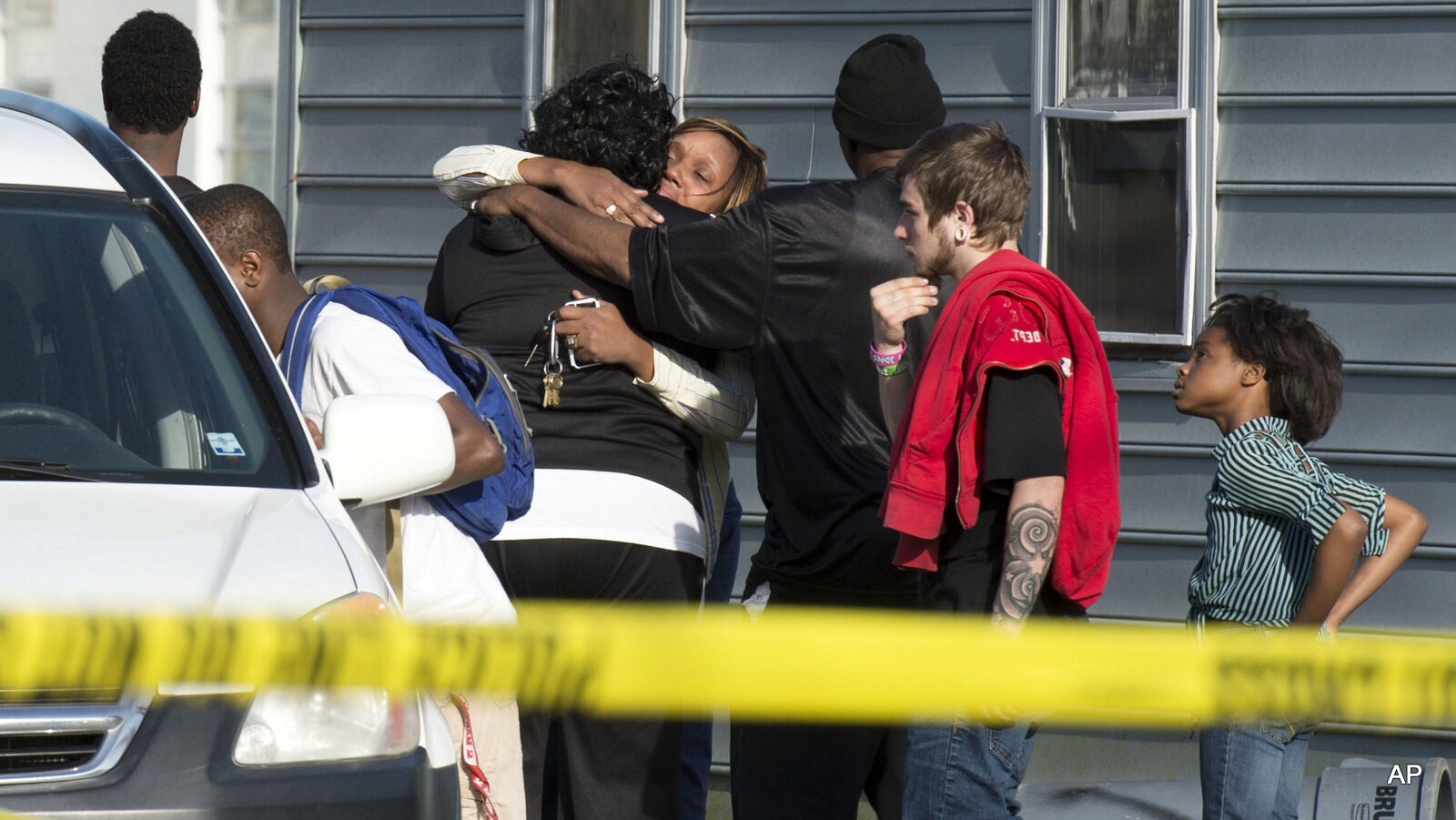 Onlookers gather outside of a house, where police say seven children and one adult have been found dead Monday, April 6, 2015, in Princess Anne, Md.