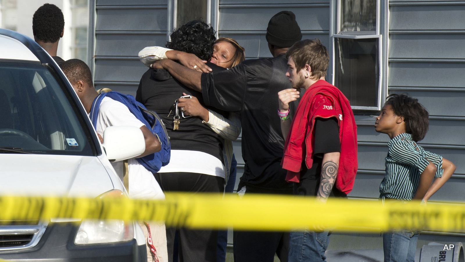 Onlookers gather outside of a house, where police say seven children and one adult have been found dead Monday, April 6, 2015, in Princess Anne, Md. 