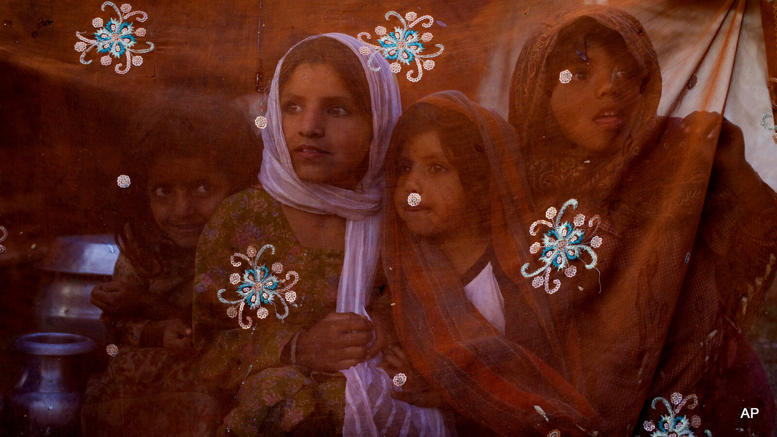 Bakarwal nomad children are seen through a veil that covers their tent as they react to a Kashmiri man photographing them on the outskirts of Srinagar, Indian controlled Kashmir, Tuesday, April 21, 2015. Bakarwals are nomadic herders of Jammu Kashmir state who wander in search of good pastures for their cattle. (AP Photo/Dar Yasin)