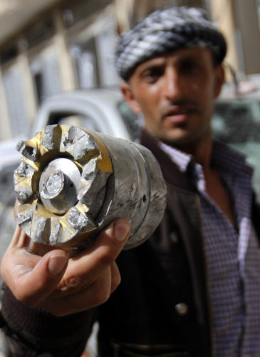 A man holds a cluster comb fragment after a Saudi-led airstrike in Yemen's capital, Monday, April 20, 2015. (AP Photo/Hani Mohammed)