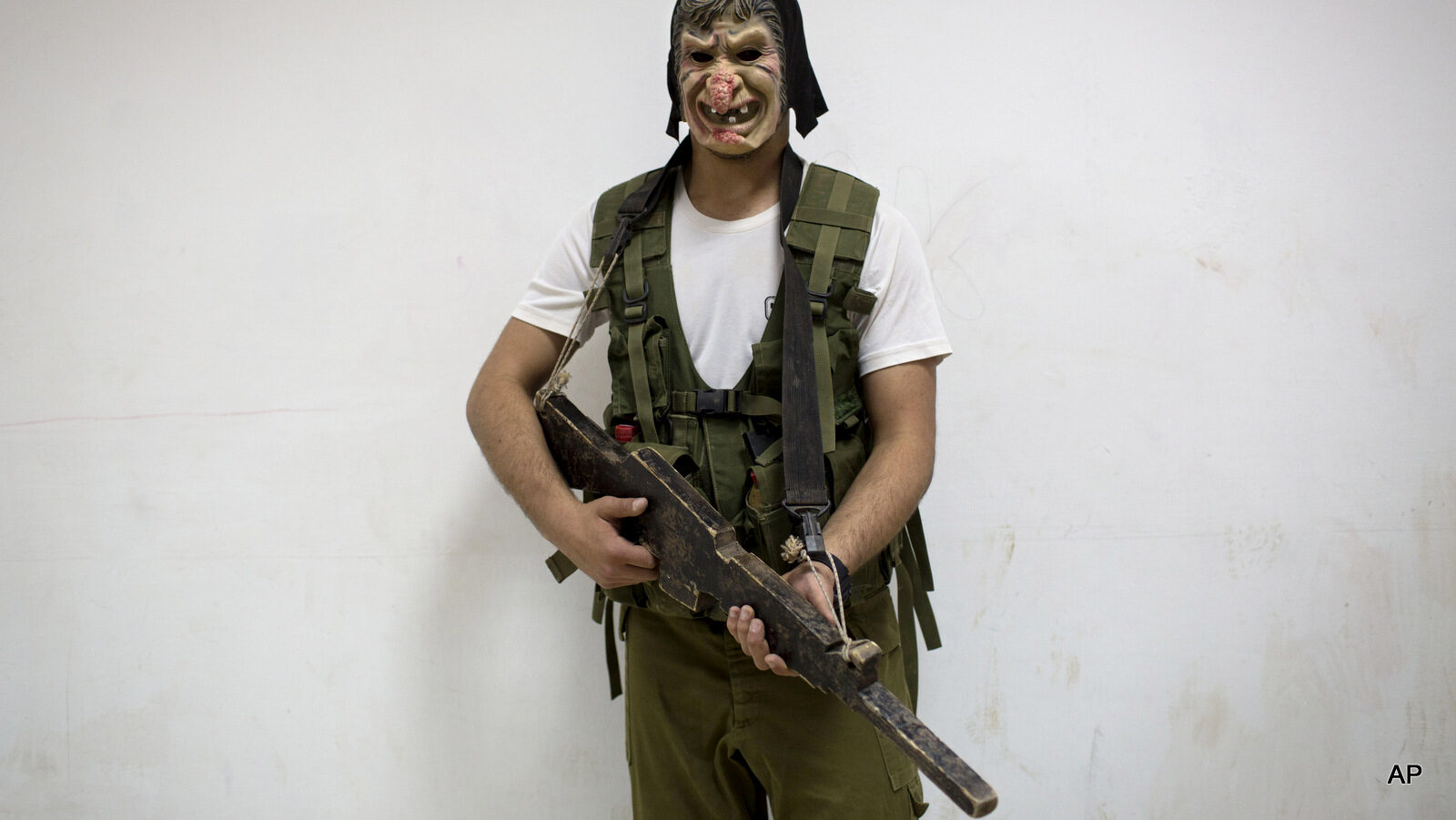 An Israeli high-school senior poses for a photograph as he wears a mask during urban fighting drill as part of privately run military combat fitness training as part of privately run military combat fitness training to prepare for national military service in Israeli settlement of Mizra, northern Israel. March 24, 2015.