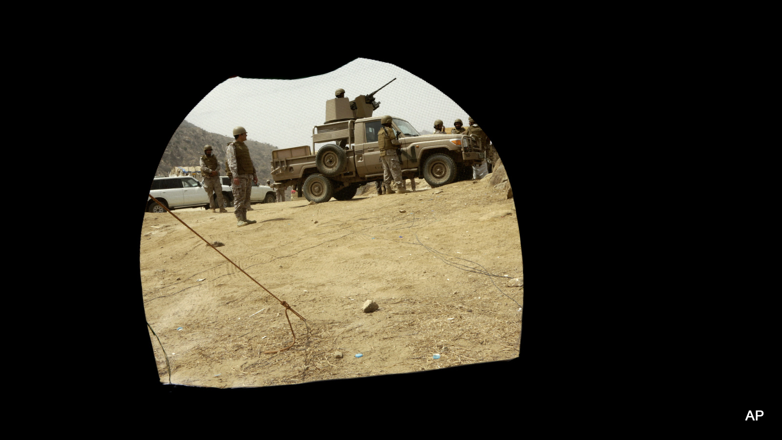 Saudi soldiers are seen through a tent positioned at the Saudi border with Yemen in Jazan, Saudi Arabia, Monday, April 20, 2015. The Saudi air campaign in Yemen is now in its fourth week.