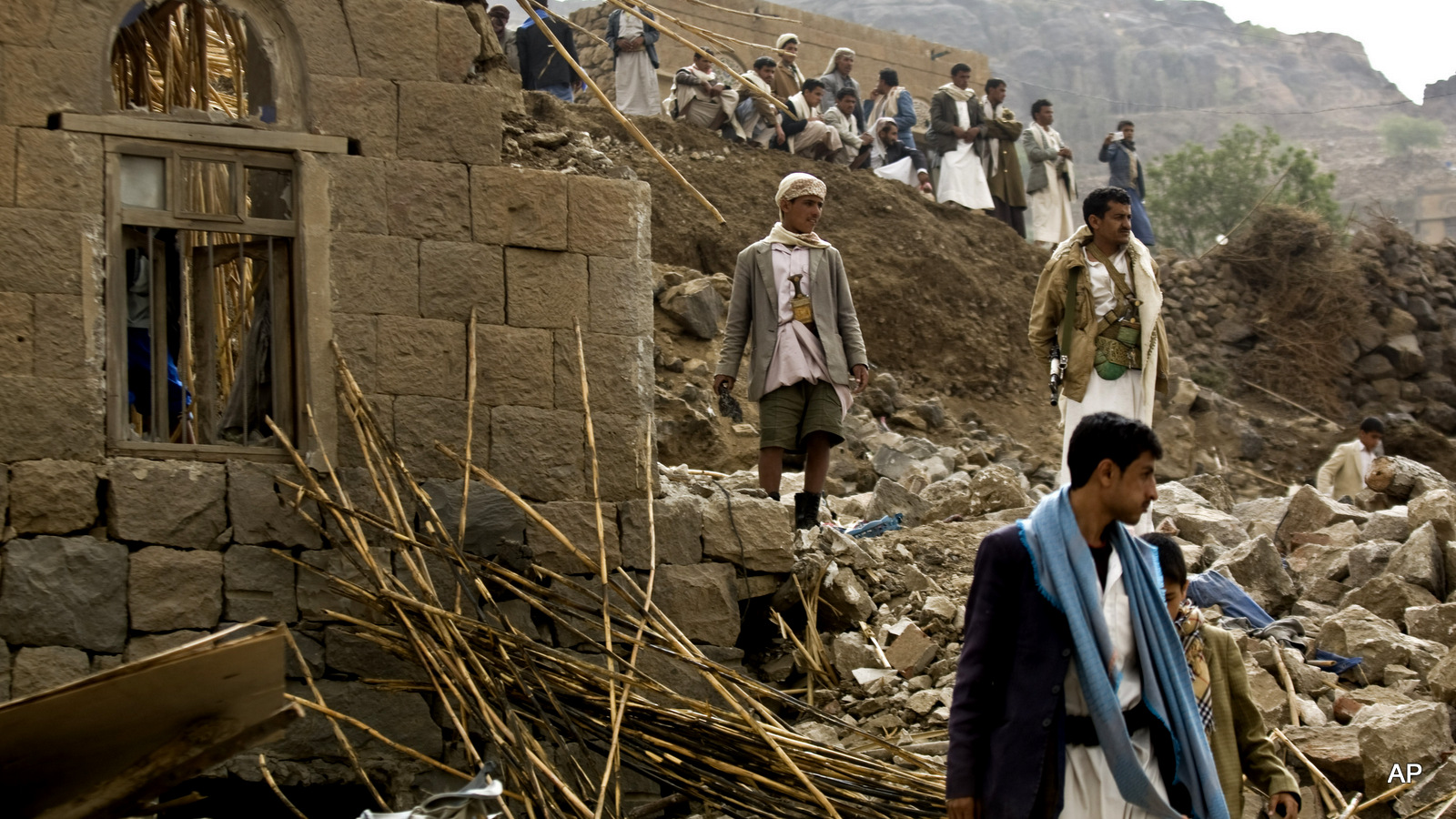 Yemenis stand amid the rubble of houses destroyed by Saudi-led airstrikes in a village near Sanaa, Yemen.