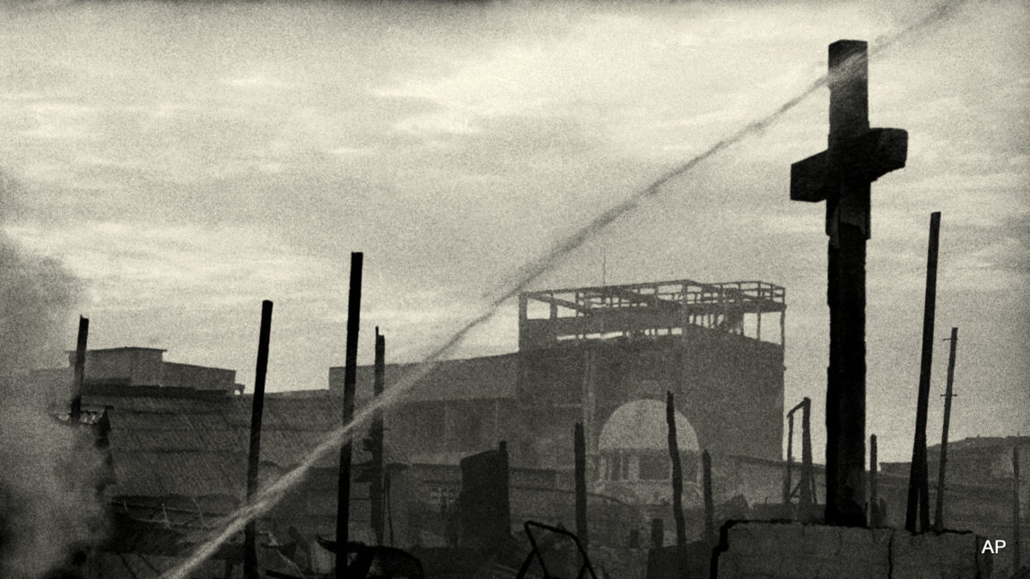 FILE - In this Sunday, April 27, 1975 file photo, a cross from a church in Saigon stands against the dawn sky after a rocket attack and ensuing fire. (AP Photo/Matt Franjola, File)